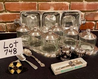 Lot 748. $30.00 Pewter-like Fleur de lis relish tray, 2 sets of 3 covered jars, crown salt and pepper set, bottle stopper and misc spoons