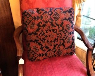 One of two charming red accent armchairs
