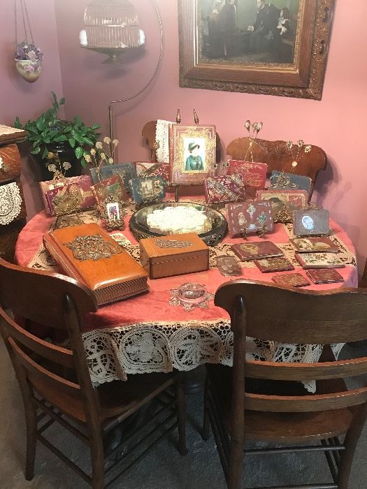 Massive claw foot Oak table. The chairs are pressed on the seat! The table is set with antique autograph books on vintage twist easel stands. Note the turn of the century wood cased photo album and keepsake box. 