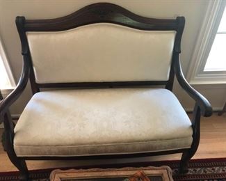 Solid wood settee with clean white upholstery