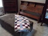 Ottoman that doubles as storage with one of the many handmade quilts.