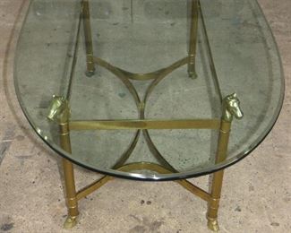ITEM 3  -Brass horse head glass top table, no chips in glass. 48"long, 26"wide, 18"high. $250.00