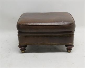 ITEM 105---leather ottoman with wood and brass feet, brass tacking. some surface wear, $75.00