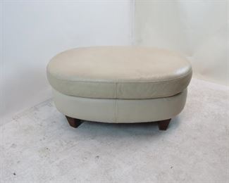 ITEM 134---contemporary oval leather ottoman.small marks on leather, 38" long, 24" wide, 17"high $50.00