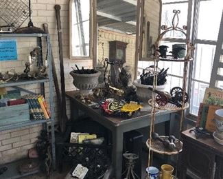 Green patio room with amazing metal shabby chic mirror, vintage cast iron cannons and hand weights, tons of trivets including owls, interesting metal pieces and more.