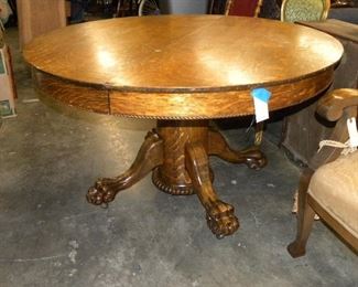 ONE OF TWO ROUND SOLID OAK CLAW FOOT TABLE