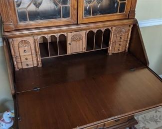 Smaller secretary with area for display on the top and desk on the bottom. There are also three drawers below the drop-down desk area.
