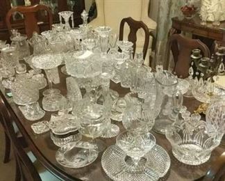 A full table of crystal and cut glass of all varieties and from all different eras, including a stunning, massive punch bowl. This stuff is priced to move