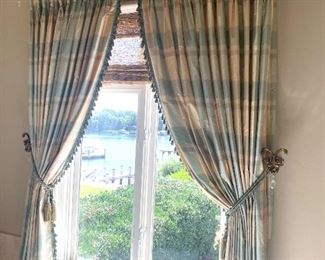 there are several windows with lined silk drapes or panels