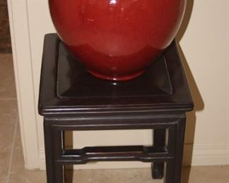 Asian style end table and red ceramic vase.