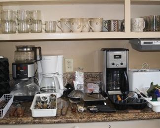 Coffee makers, expresso, toaster, spice rack, scales, utensils dishes.