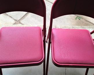 Two of four red folding chairs
