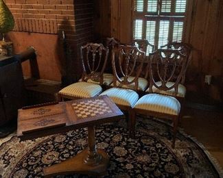 Antique game table, mediums sized circular rug, 6 chairs, chandelier 