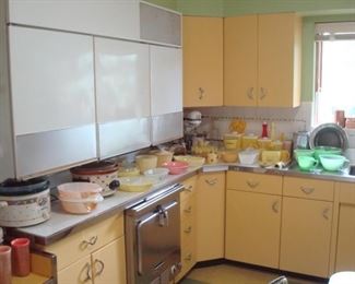 Kitchen: An overview of the vintage kitchen.  Notice the yellow metal cabinets and built-in oven.  The three upper white cabinets on the left are actually the 1953 refrigerator!  No, none of the built-ins are for sale.  It all stays with the house and its lucky new owner.  But, all of the items displayed on the counter-tops are for sale.