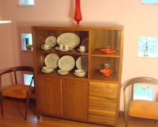 Dining Area:  A Mid-Century Modern "American of Martinsville" display credenza is flanked by two Mid-Century Modern (Danish) side chairs.  It displays several pieces of 1950's "Franciscan - Atomic Oasis" earthenware and mid-century modern glass and ceramics.  The display credenza has two sliding glass doors above two left flat cabinet doors [with two interior shelves], open shelves and four louvered front drawers on the right.  It measures 50" wide x 18" deep x 58" tall.