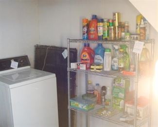 Lower Level:  A MAYTAG washer is near a pet crate, a four-shelf chrome rack, and various household goods.