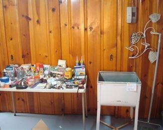 Lower Level: Various hand tools are to the left of a vintage wash tub and hanging plant holder.