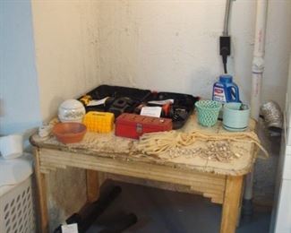 Lower Level:  A vintage wood kitchen table displays two drills (one DeWalt and one Black & Decker in cases) as well as sets of DeWalt drill bits and various household goods.