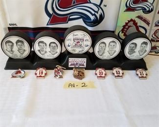 AV-2 ($60) 1995-96 Stanley Cup Avalanche display with 5 pucks, 6 hat pins and metallic stickers.