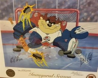 AVB-3 ($100) Taz as an Avalanche Goalie in this limited edition litho-serigraph signed by Patrick Roy, Stephane Fiset (artist) and the McKimson Bros from Looney Tunes.  Comes framed and with the COA.  Limited Edition #231/250.  Measures  28" x 24.5"