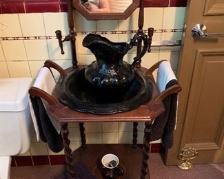 An antique washstand including a wash bowl and water pitcher