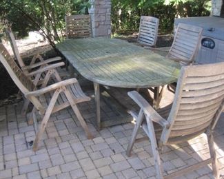 Teak patio table with six matching  adjustable chairs.