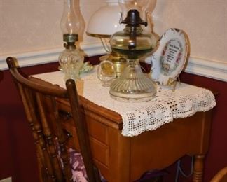 More Collectible Oil Lamps sitting atop a Beautiful Antique Sewing Machine Cabinet containing a Beautiful Antique Singer Sewing Machine, plus and Antique Chair
