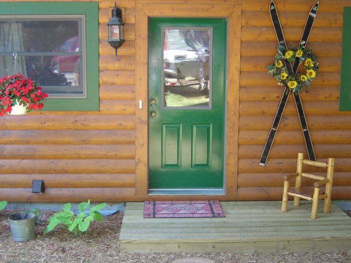 Antique skis & seasonal wreaths, small pine log chair