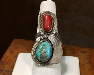 #108...Signed size 7 1/4 Native American made silver ring. Features large turquoise nugget cabochon and coral cabochon set in smooth bezels with a large silver feather and three silver rain drops. Split shank band. Signed CKB. $220