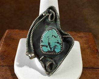 #57...Funky cool size 10 old pawn silver ring with a turquoise cabochon (has nice black matrix) in a shadowbox setting. Framed with silver twisted rope-style wire, decorated with two smooth silver curly cues and two silver raindrops. Split shank band. $180