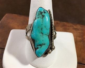 #29...Super nice size 10 Native American made silver ring with a superb long polished turquoise nugget that has great black matrix. Decorated on one side with silver twisted rope-style wire and two silver rain drops. Split shank band. $175