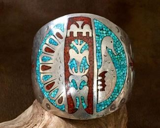 #23...STUNNING museum-quality Native American made sterling silver, turquoise and coral chip inlay cuff bracelet. Beautiful designs of a turkey and corn in the center medallion and on the sides. There is no loss in any of the chip inlay areas. Unsigned but attributed to J. Nelson (Navajo). Tapered width from 2 3/8" at front center to 1" in back. Total circ. (6 1/8 " inner circ. with 1 5/16" gap). Not flexible. $980