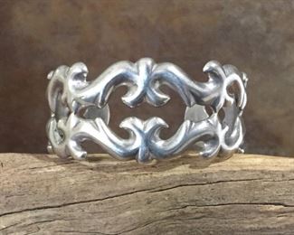 #28...Signed Frank Chee (Navajo) cast sterling silver cuff bracelet. Total circ. 6 5/8" (5 1/2" inner circ. with 1 1/8" gap). Width tapers from 1 1/8" at center front to 7/8" in back. Signed F. CHEE NAVAJO, stamped STERLING. Not flexible. $300