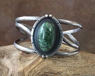 #30...Signed mid-century Mexican sterling silver cuff bracelet with a beautiful green stone cabochon. Total circ. 7" (inner circ. 5 3/4" with 1 1/4" gap). Width tapers from 2 3/8" at center front to 3/8" in back. Signed HECHO EN MEXICO ART.PLAT, stamped 925 PLAT. Flexible. $200