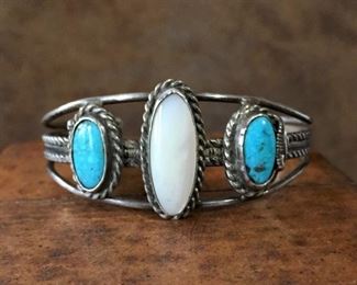 #31...Signed Native American made sterling silver, turquoise and mother of pearl cuff bracelet. Center medallion size is 7/16" x 1". Total circ. 6 1/8" (5" inner circ. with 1 1/8" gap). Signed with indiscernible mark (looks like Papel?), stamped STERLING. Slightly flexible. $200