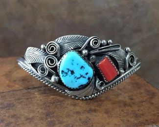 #33...Signed Justin Morris (Navajo) sterling silver, turquoise and coral cuff bracelet. Width tapers from 1 1/8" at front center to 3/16" in back. Total circ. 7 1/8" (5 5/8" inner circ. with 1 1/4 " gap). Signed Justin Morris Navajo Sterling Silver. Slightly flexible. $300