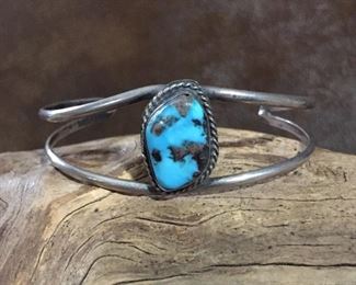 #97...Native American made sterling silver and turquoise cuff bracelet. Width tapers from 7/8" at front center to 3/16" in back. Total circ. 6 1/2" (5" inner circ. with 1 1/2" gap). $180