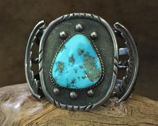 #36...Native American made old pawn sterling silver and turquoise cuff bracelet. Features a large triangular-shaped turquoise cabochon that has little pyrite flecks. Flanking the large centerpiece are beautiful curved silver feathers. Size of the centerpiece is 1 3/4" x 2 1/8". Total circ. 6 7/8" (5 3/4" inner circ. with 1 1/8" gap). $800