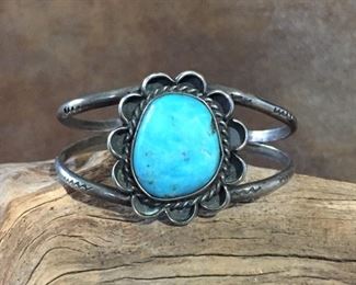 #60...Native American sterling silver and turquoise cuff bracelet. Features a really beautiful turquoise cabochon. Double band is decorated with squiggly snake stamps. Total 6 3/8" circ. (5 1/8" inner circ. with 1 1/4" gap). Size of framed cabochon is 1 1/8" x 1 1/4". Slightly flexible. $300