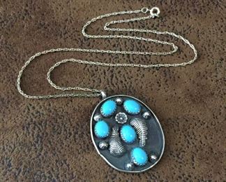 #73...Native American made sterling silver pendant decorated with five turquoise cabochons set in sawtooth bezels, six stamped sterling rain drops, two feathers and a flower. Pendant is 1 1/4" x 1 3/4" (including bale). Sterling chain is 18" long. $180