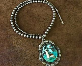 #79...Stunning 26" long sterling silver Navajo pearls necklace, beads range from 10mm to 4mm. The unique 2 3/8" x 3 3/8" sterling silver pendant features a beautifully composed turquoise (3 kinds), amber, onyx and coral inlay scene of a lighthouse. Enlarge our pics to check out the amazing 3D artistry of this piece! Pendant signed with TH and stamped STERLING. $800