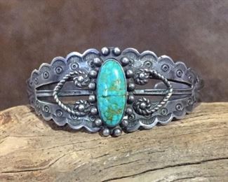 #44...Harvey era Native American sterling silver cuff bracelets with oval turquoise cabochon, silver decorations and stampings (including arrows and thunderbirds). Total circ. 6 5/8" (5 3/8" inner circ. with 1 1/4" gap). Width tapers from 15/16" (front center) to 1/4" in back. Turquoise is cracked but intact (price reflects this). Slightly flexible. $180