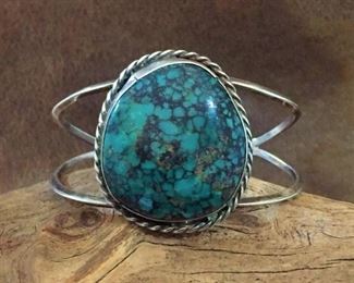 #94...Native American sterling silver and turquoise cuff bracelet. Features a huge, deep teal-colored turquoise with stunning black spiderweb matrix. Total 6 7/8" circ. (5 3/4" inner circ. with 1 1/8" gap). Size of framed cabochon is 1 3/8" x 1 5/8". Slightly flexible. $480
