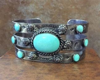#40...Vintage Native American turquoise cuff bracelet. Width is 1 1/8"; total circ. is 6 5/8" (5 3/4 inner circ. and 7/8" gap). Size of large center cabochon is 3/4" x 9/16". Stamped STERLING. Very slightly flexible (not recommended). $480