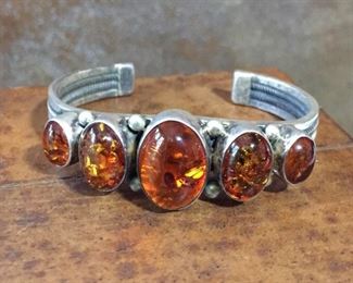 #68...Sterling silver and amber cuff bracelet from the same estate as the amber necklace and earrings. Total circ. 6 1/4" (5 1/4" inner circ, and 1" gap). Slightly flexible (not recommended). Signature partially worn away on edges. $368