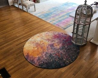 Round rug. Front entrance. Wooden bird cage for decoration.