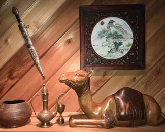 Wooden camel sculpture. Chinese signed enamel on porcelain plaque (on wall). North African dagger (on wall). 