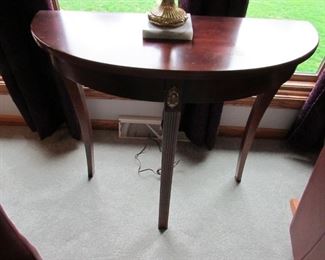 Demilune console table with gilt-metal mounts. 30"w x 12"d x 29" tall. PRICE: $95.00