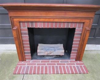 Portable electric fireplace with cherry finish. The detachable faux brick hearth stands out an additional 13". Faux logs plug into wall via electric cord. This piece is decorative only and is NOT for heat. Looks great in a rec room. 60.75" wide x 46.5" tall x 15.5" deep. PRICE: $150.00