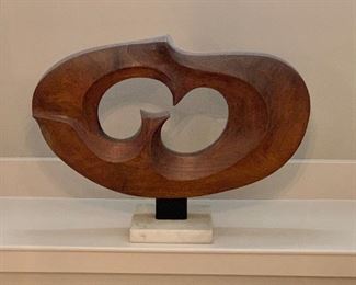 Wooden modernist sculpture on base. Approx 35" wide, 25.5" high